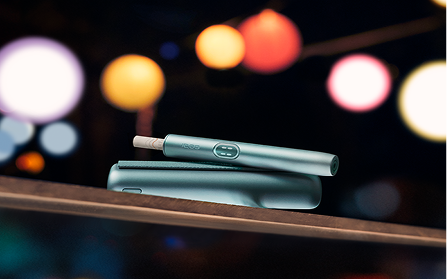 Ein IQOS ILUMA i Gerät vor einem leuchtendem Hintergrund