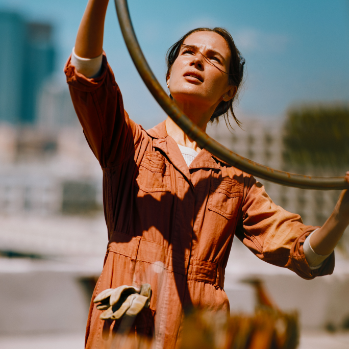 Persona sosteniendo IQOS Iluma i turquesa mientras sube escaleras metálicas en exterior