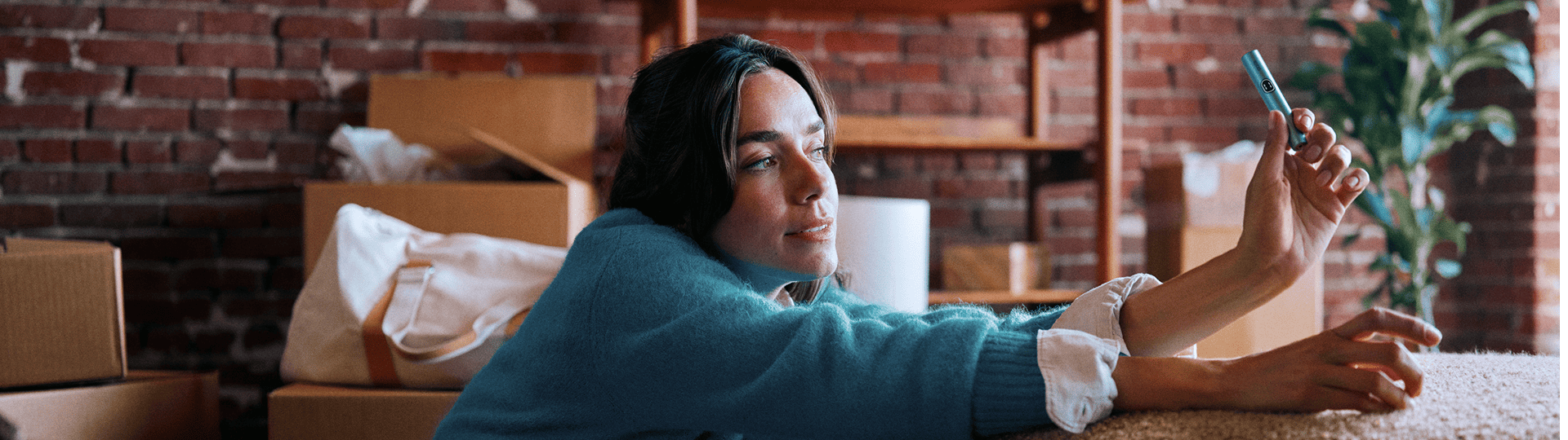 Mujer sosteniendo un IQOS ILUMA i PRIME en color Breeze Blue con sus manos