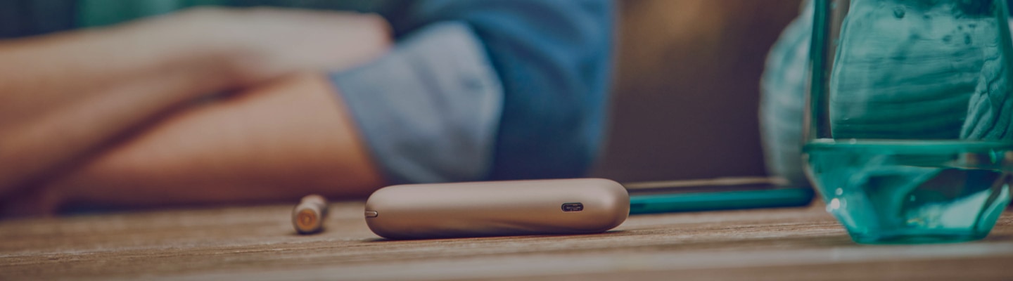 Blond girl with her gold IQOS kit in her hands