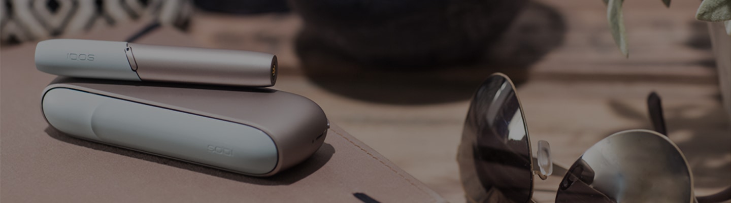 White IQOS 3 on a table of a bar