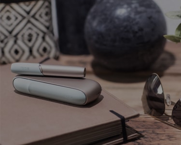 White IQOS 3 on a table of a bar