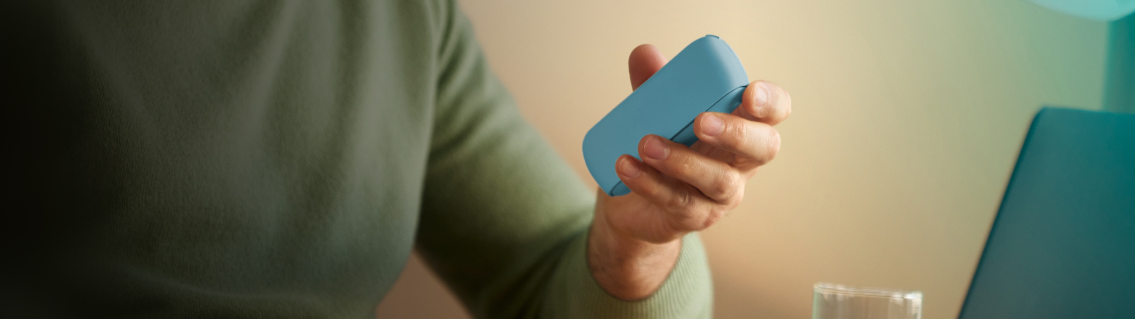 Man holding IQOS Originals DUO in turquoise