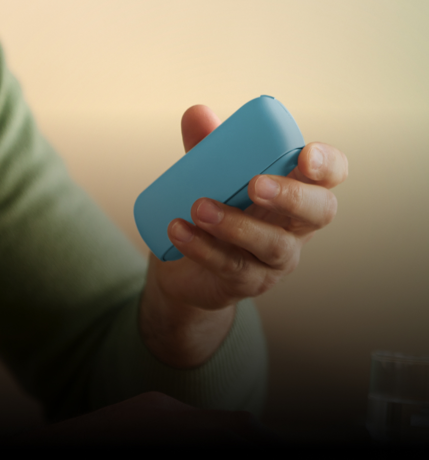 Man holding IQOS Originals DUO in turquoise