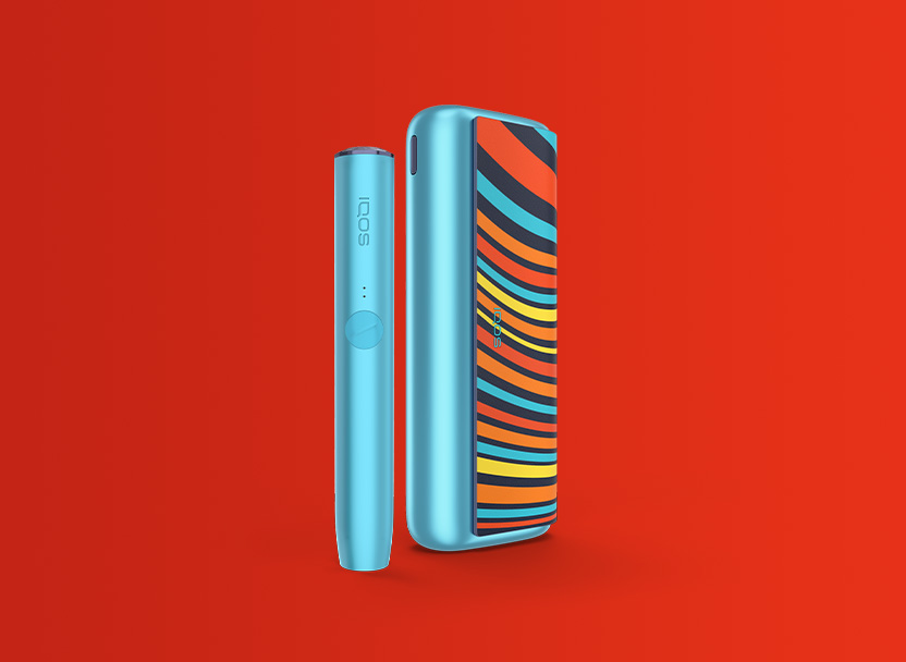 Zařízení IQOS ILUMA WE PRIME limitovaná edice na červeném pozadí.