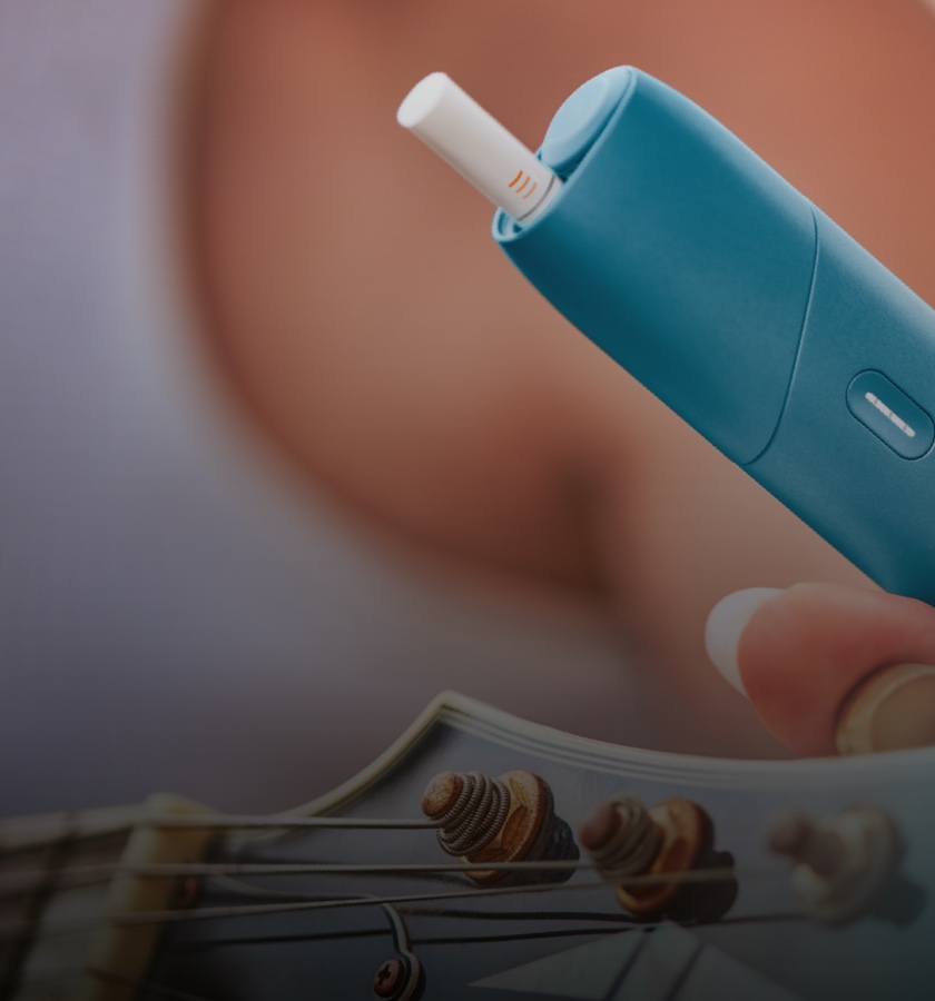 Eine Frau hält einen IQOS ORIGINALS ONE in der Farbe türkis