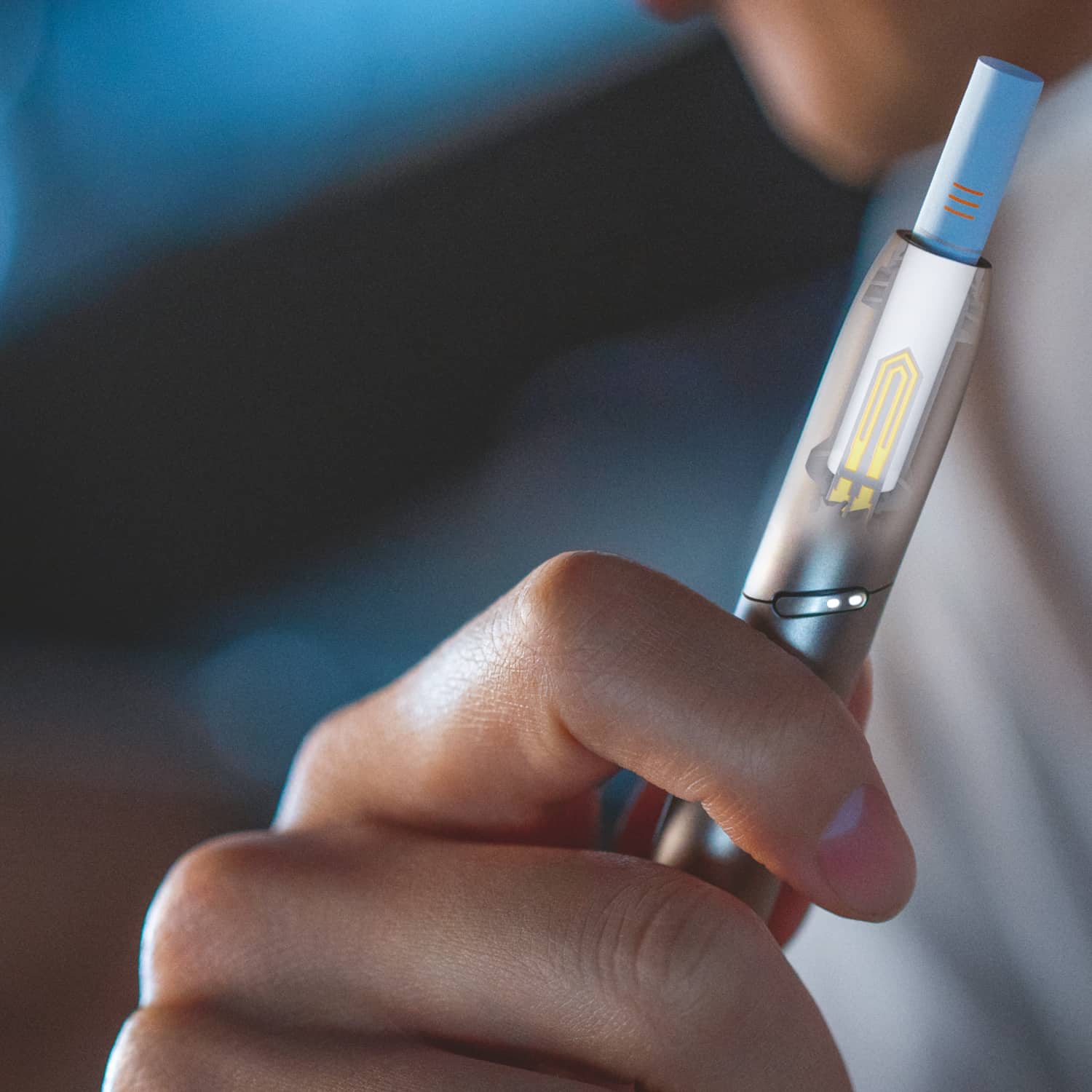 Hand hält silbernen IQOS DUO Holder, Heizblatt sichtbar
