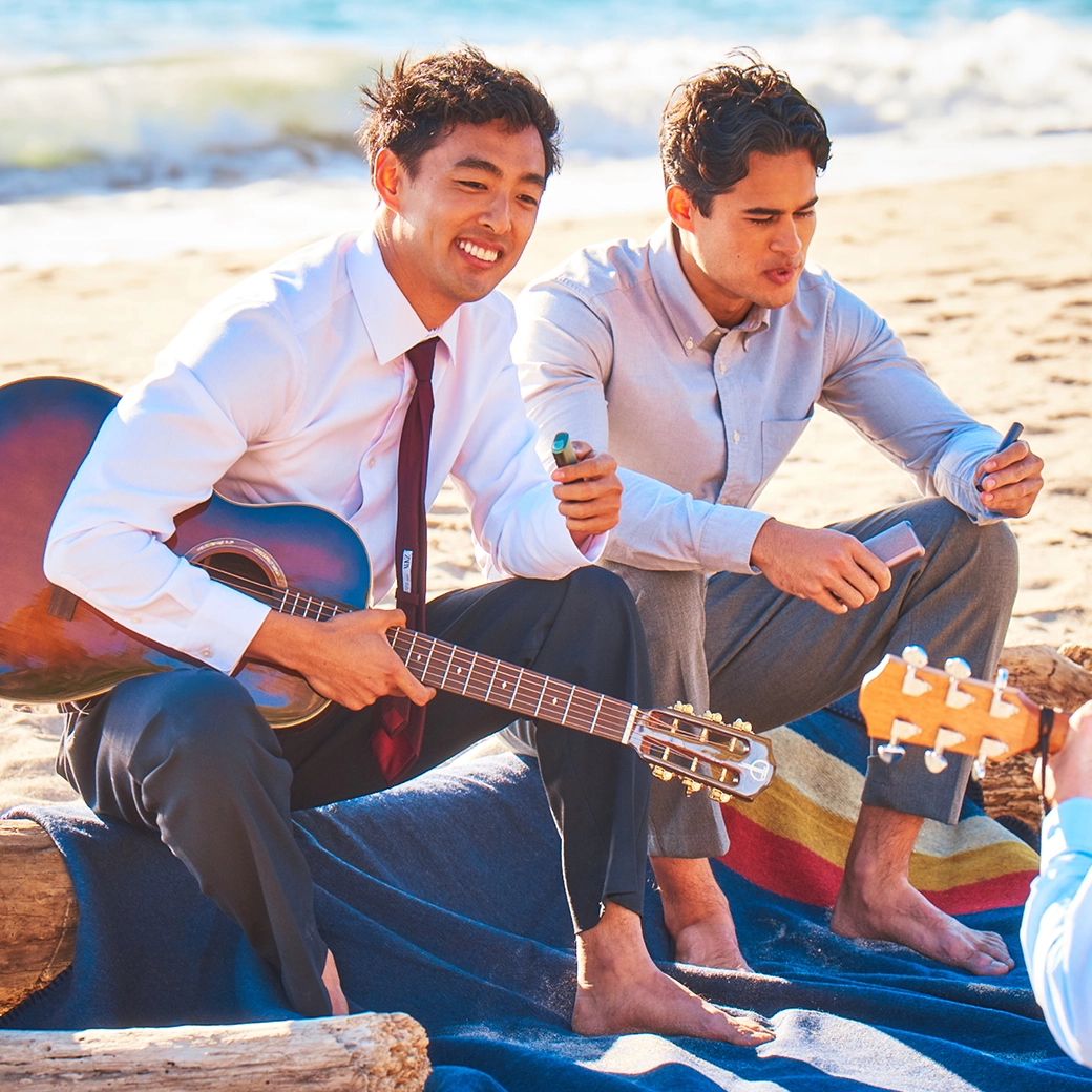 2 men are chilling ta the beach