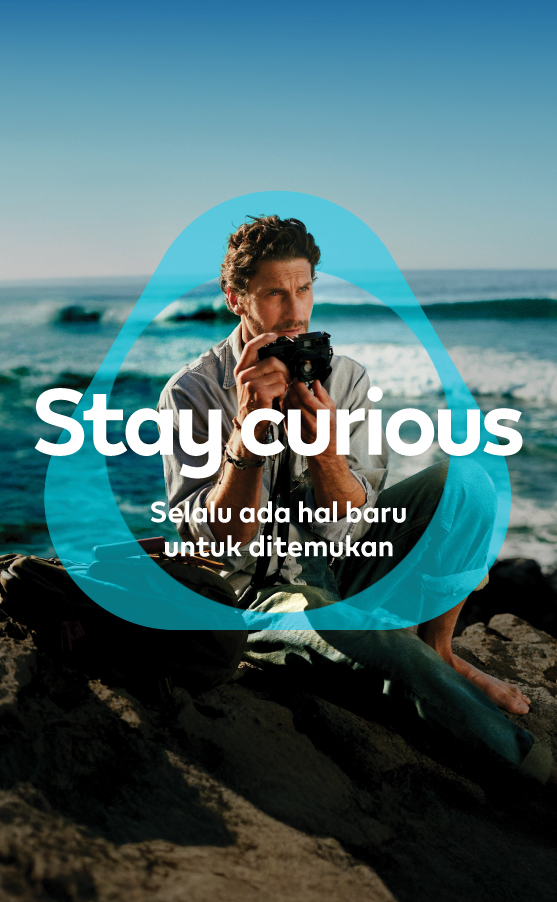 Banner Stay Curious IQOS – Seorang pria memegang kamera mencoba hal baru 