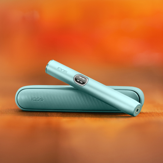 Устройство IQOS ILUMA i цвета Лазурный бриз над зарядным устройством