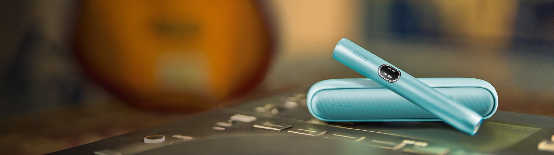 Устройство IQOS ILUMA i цвета Лазурный бриз на поверхности