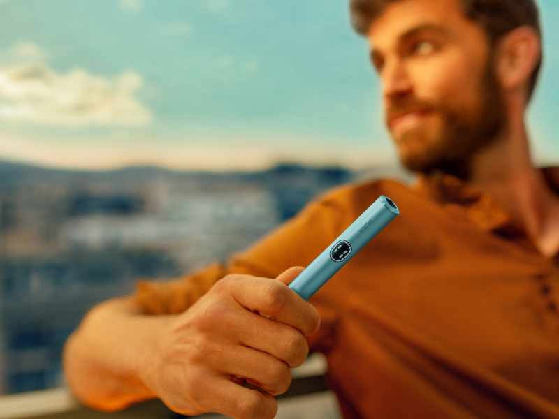 a person holding IQOS ILUMA I BREEZE BLUE HOLDER