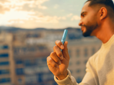 A MAN HOLDING IQOS ILUMA I HOLDER BREEZE BLUE