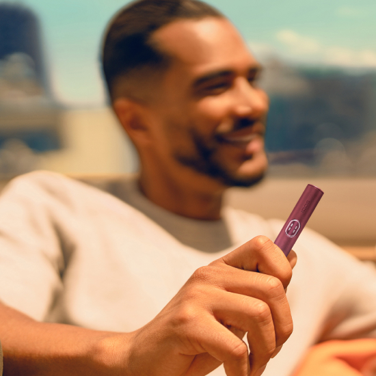 Man holding a Garnet Red IQOS ILUMA i PRIME device