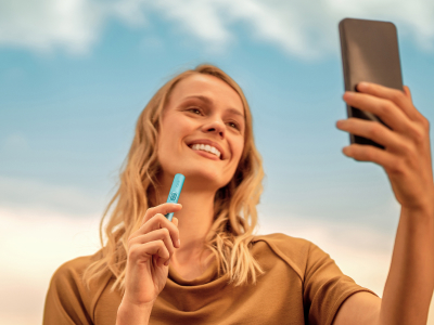A WOMAN HOLDING IQOS ILUMA I HOLDER BREEZE BLUE