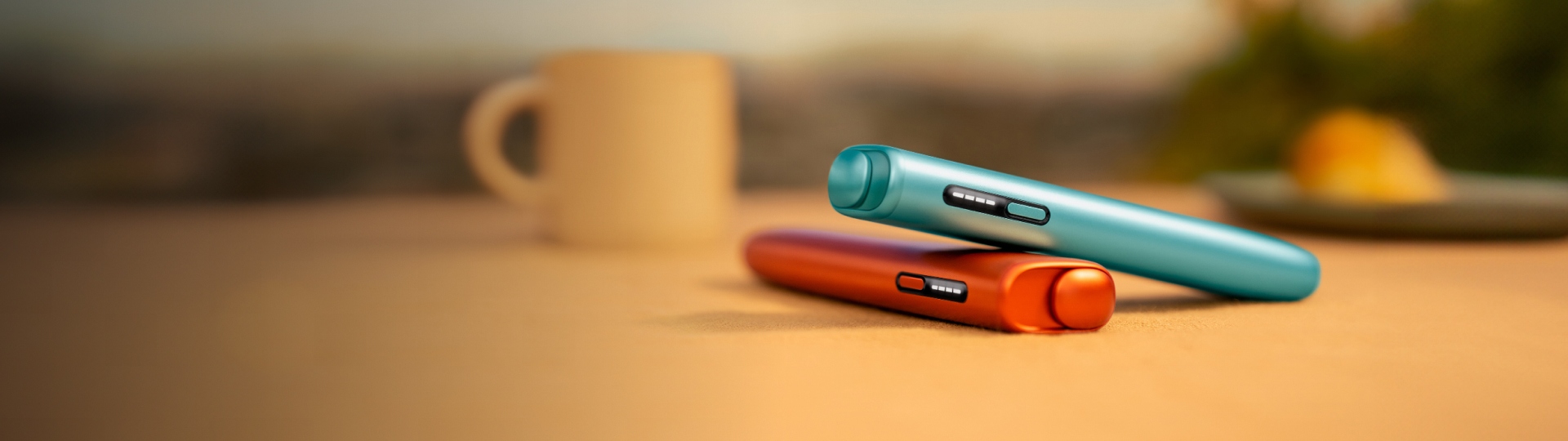 Blue IQOS ILUMA i ONE above a red IQOS ILUMA i ONE