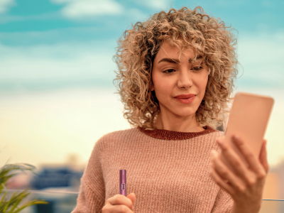 A WOMAN HOLDING IQOS ILUMA I HOLDER DIGITAL VIOLET