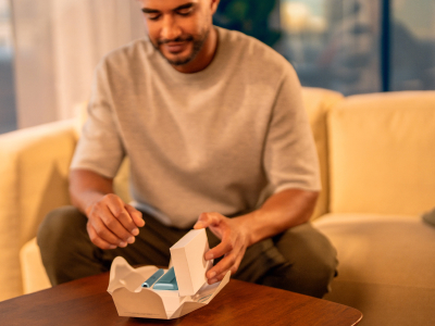 Man unboxing an IQOS ILUMA i PRIME device