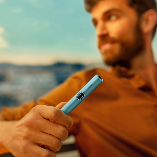 A MAN HOLDING IQOS ILUMA I HOLDER BREEZE BLUE
