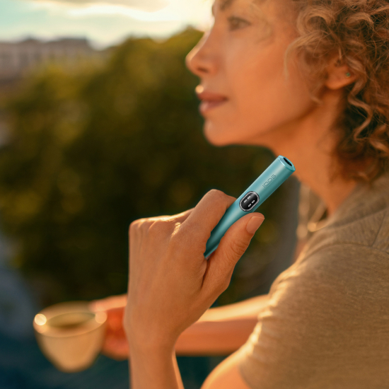 A WOMAN HOLDING IQOS ILUMA I HOLDER BREEZE BLUE
