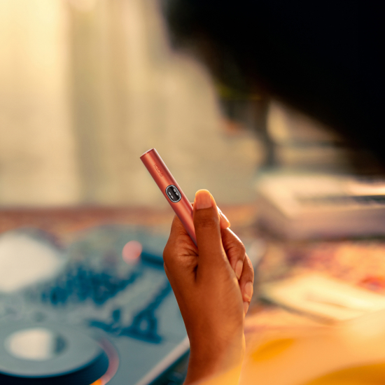 A PERSON HOLDING IQOS ILUMA I HOLDER VIVID TERRACOTTA