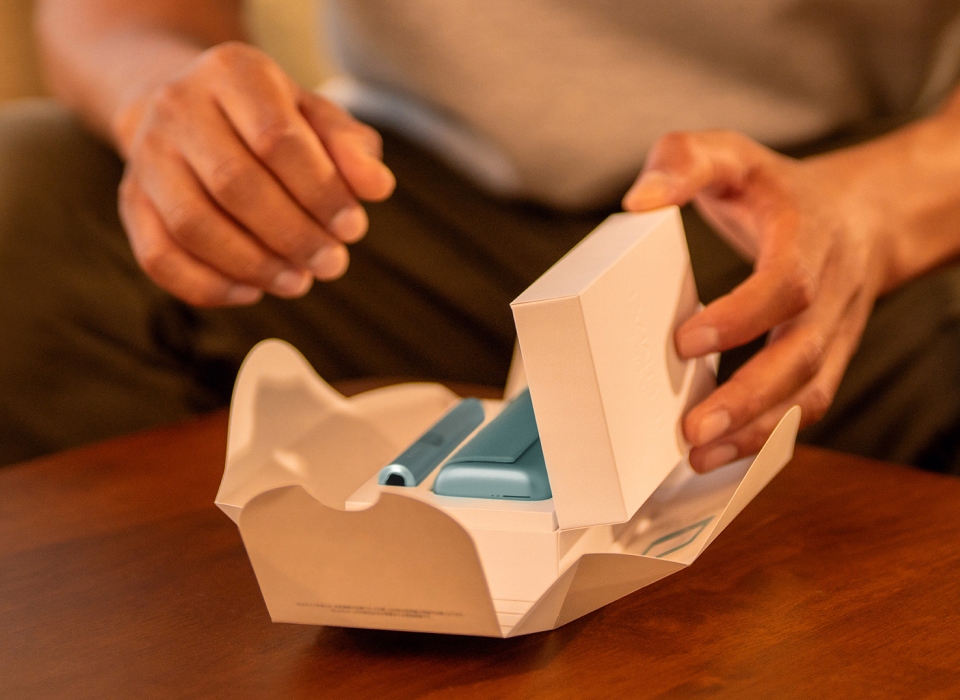Hand unboxing an IQOS ILUMA i PRIME Breeze Blue