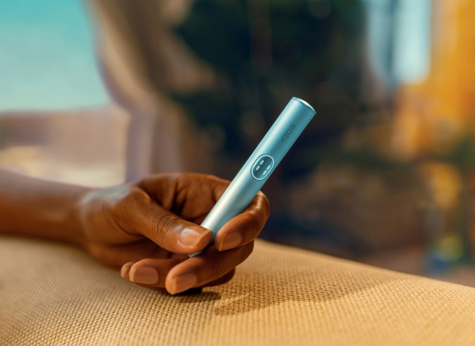 Hand holding an IQOS ILUMA i Holder Breeze Blue