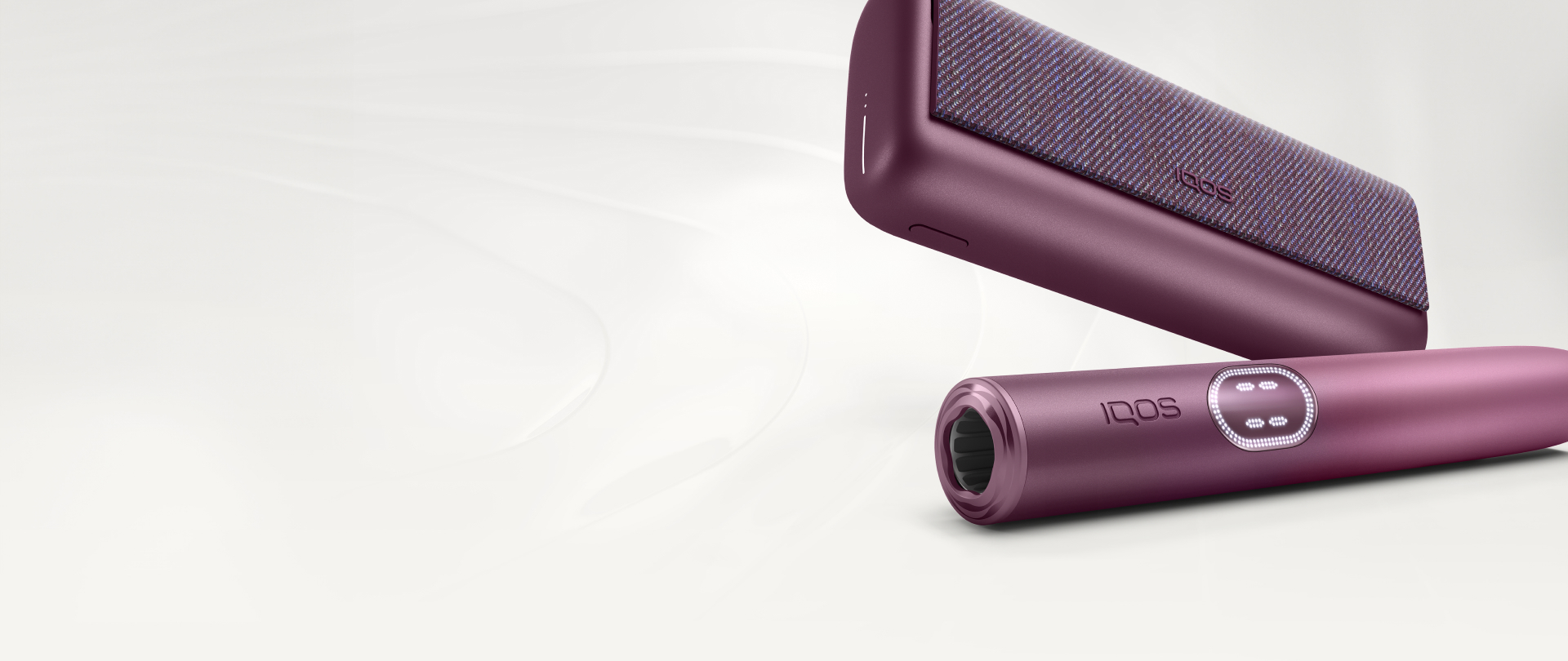 Garnet Red IQOS ILUMA i Prime Holder and Charger against a white textured background.
