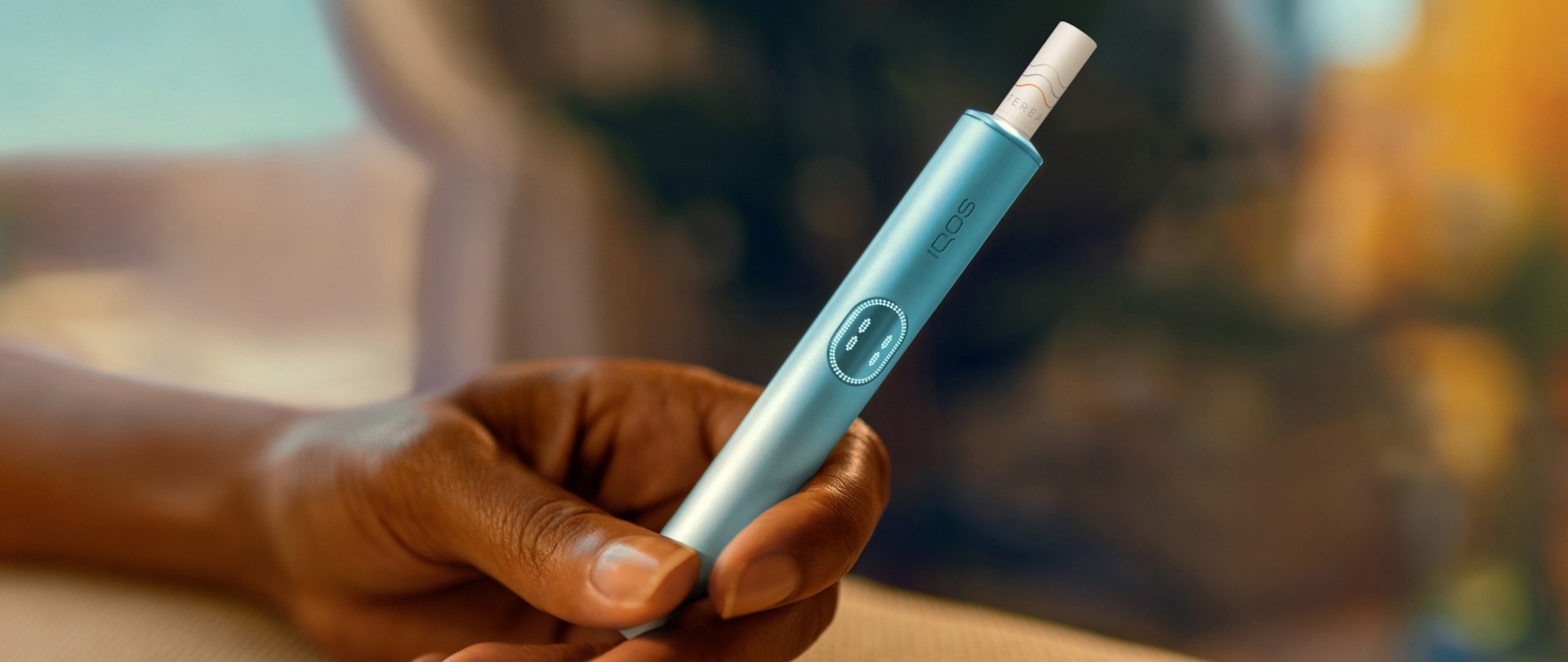 Hand holding an IQOS ILUMA device