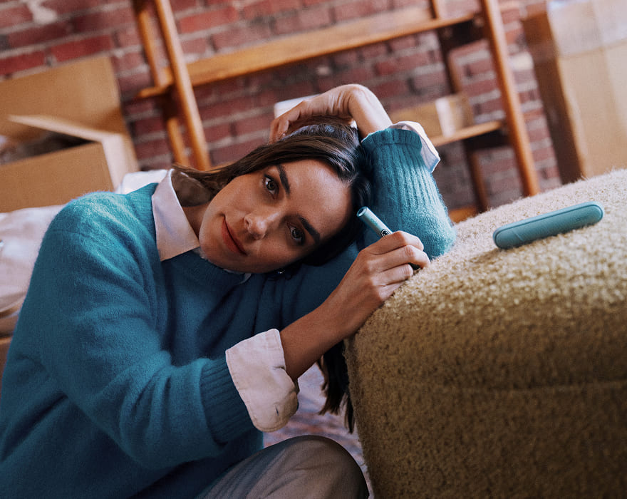 Zařízení IQOS ILUMA i PRIME a VEEV ONE na sedačce auta