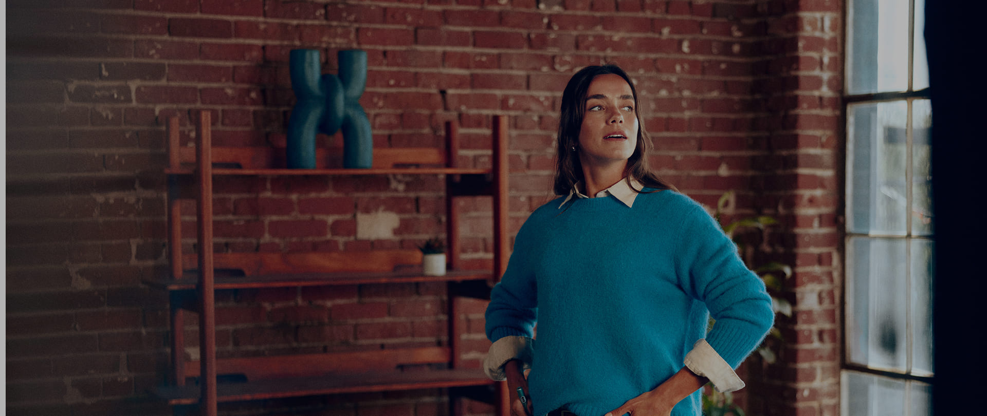A woman holding an IQOS ILUMA i color Breeze Blue in her hand