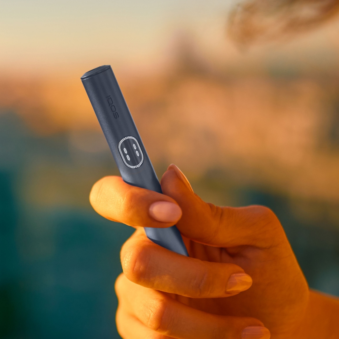 Hand hält einen IQOS ILUMA i PRIME Holder in Midnight Black.