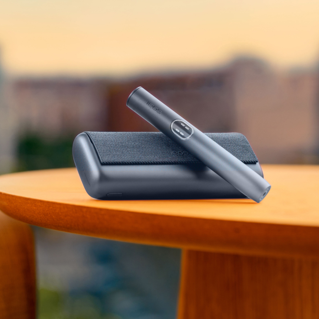 Ein IQOS ILUMA i PRIME Gerät in der Midnight Black, bestehend aus einem Holder und einem Pocket Charger
