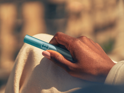 Əlində blue IQOS ILUMA i PRIME cihazı tutan şəxs
