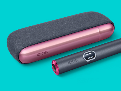 Устройство IQOS ILUMA i рядом с зарядным устройством, с индивидуальной дверцей и кольцом