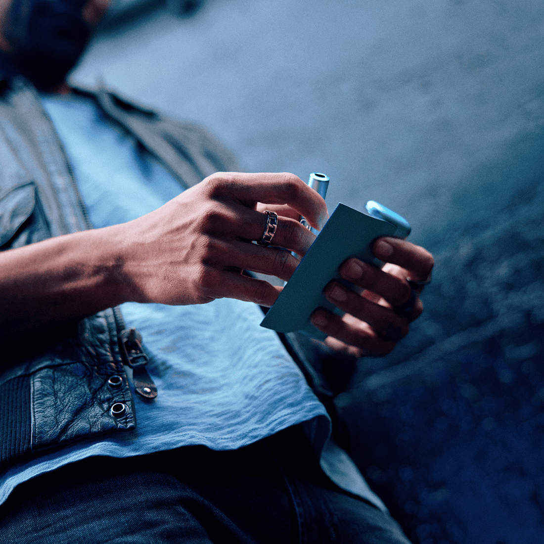 Hombre sosteniendo en sus manos un IQOS ILUMA i PRIME en color Breeze Blue