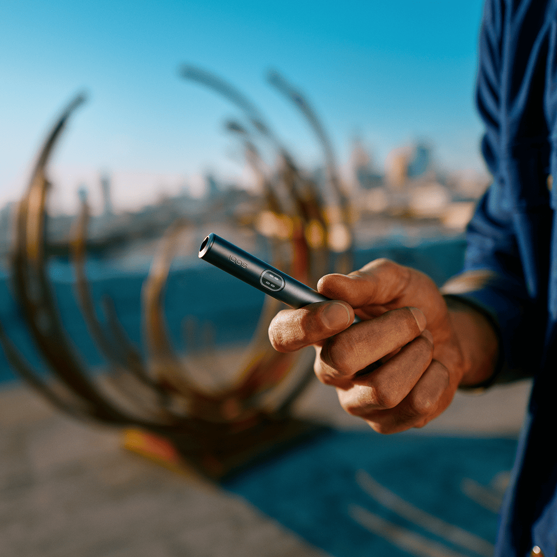 Persona sosteniendo un IQOS ILUMA i PRIME color Midnight Black con sus manos