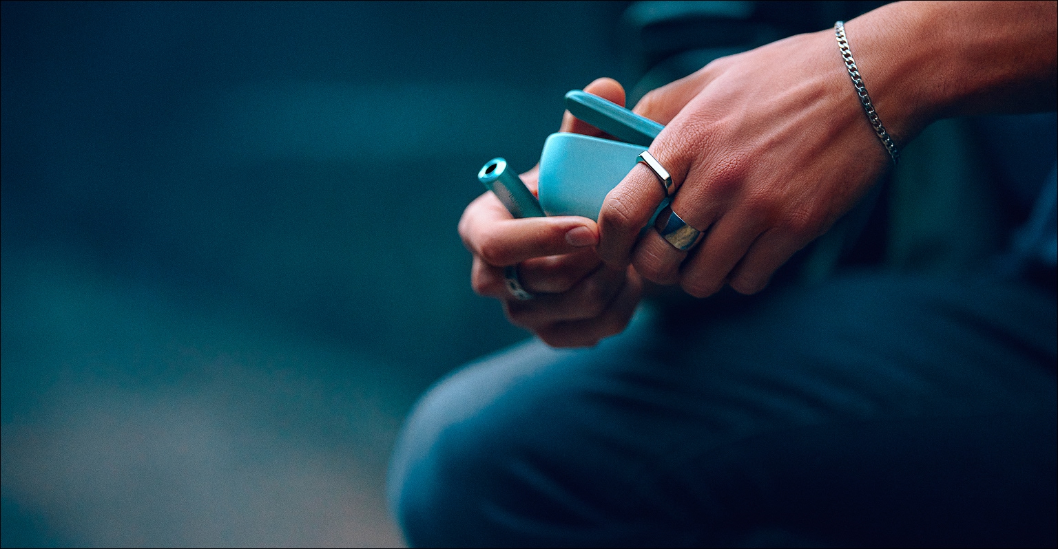 Persona sosteniendo un IQOS ILUMA i color Breeze Blue en su mano