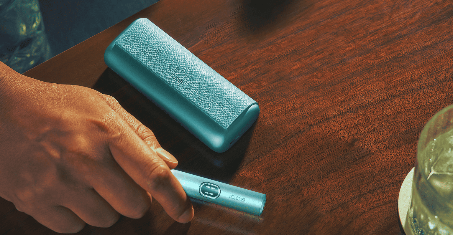 Persona sosteniendo un IQOS ILUMA i PRIME color Breeze Blue en su mano