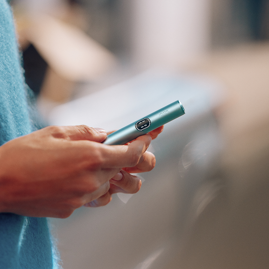 Persona sosteniendo un IQOS ILUMA i color Breeze Blue