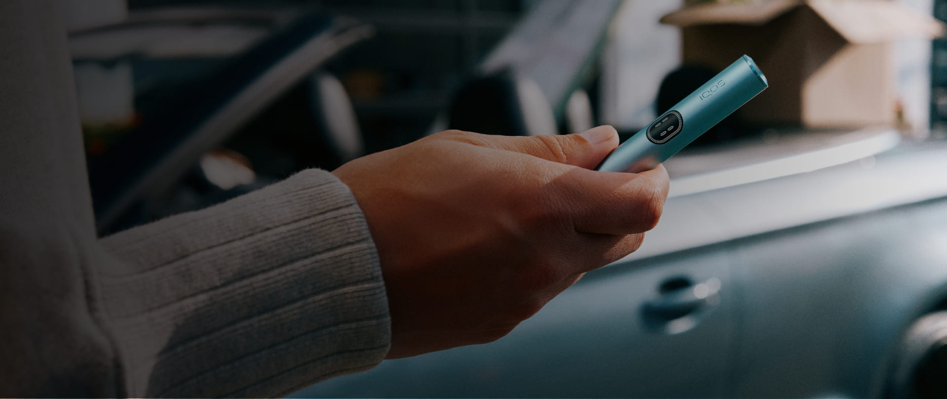 Persona sosteniendo un IQOS ILUMA i PRIME en Color Breeze Blue en la mano
