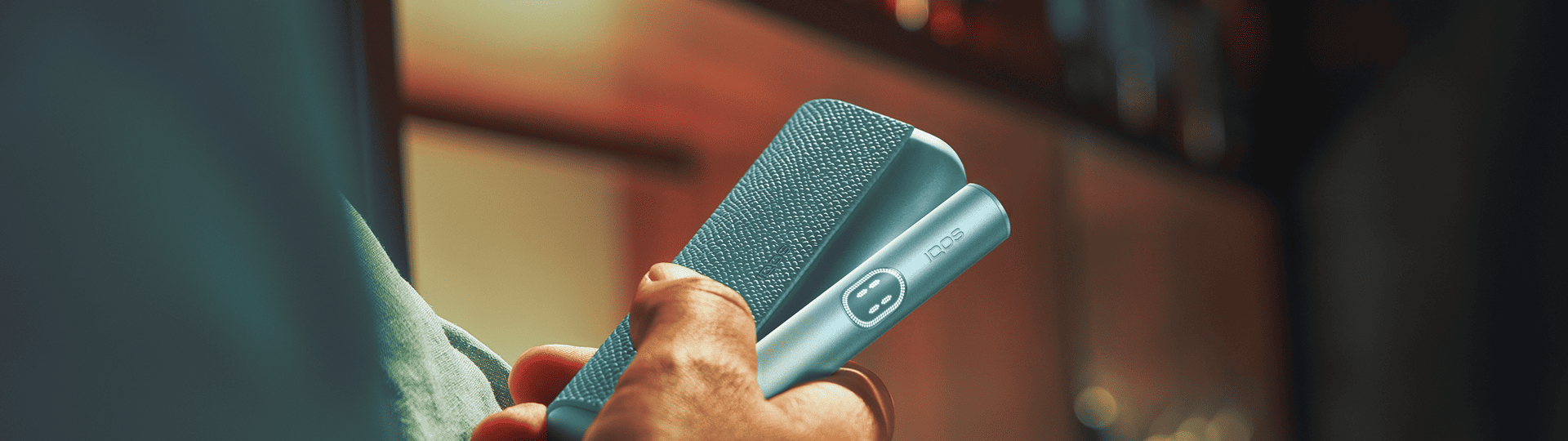 Persona sosteniendo un IQOS ILUMA i PRIME color Breeze Blue con sus manos