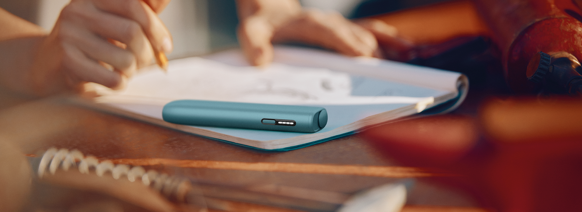 Un IOQS ILUMA i ONE color Breeze Blue acostado sobre un cuaderno