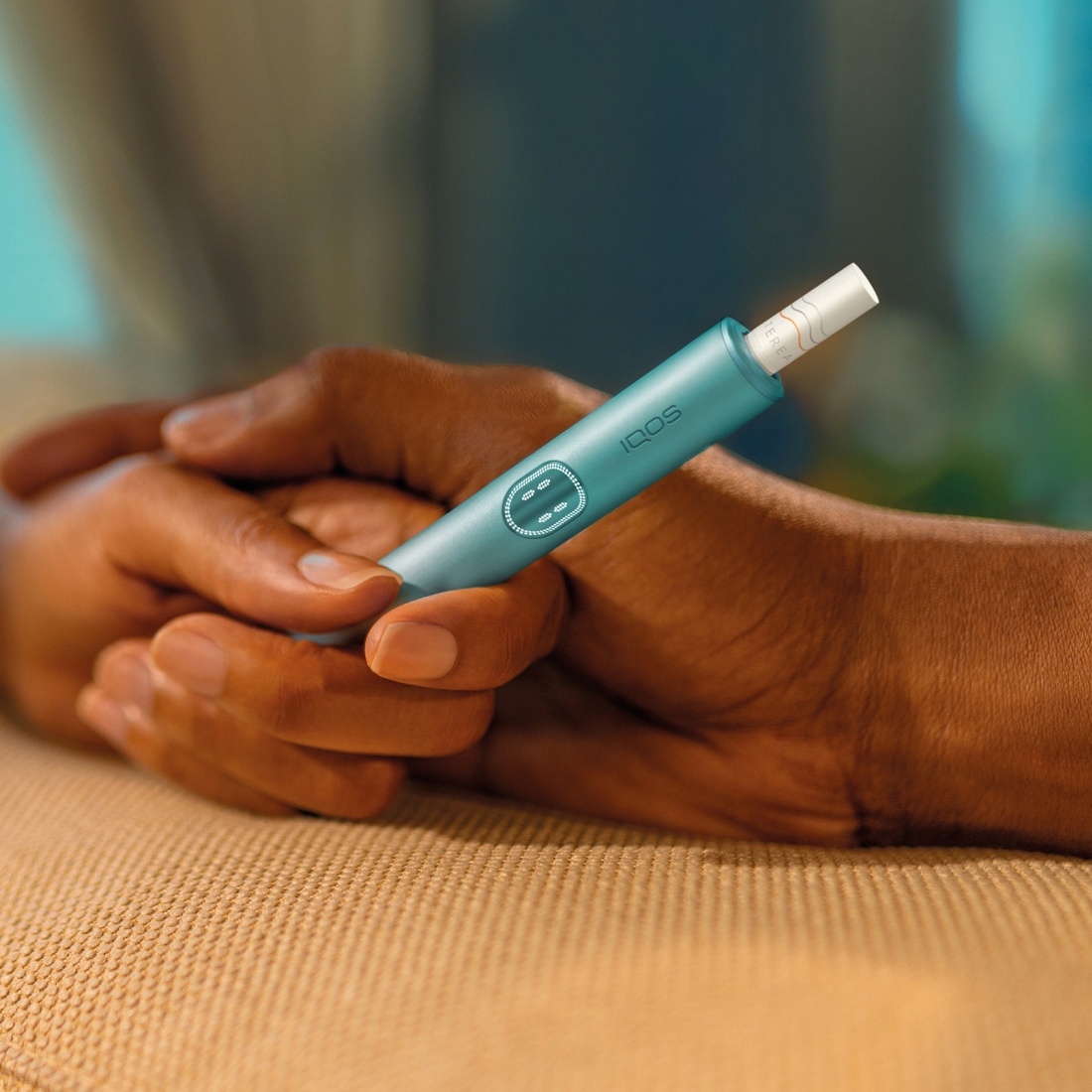 Two hands holding together an IQOS ILUMA i PRIME device