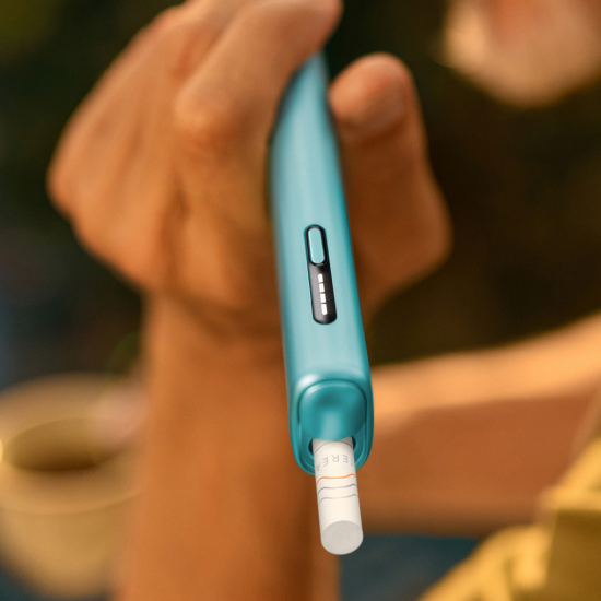 تفاصيل يد تحمل جهاز IQOS ILUMA i أزرق اللون.