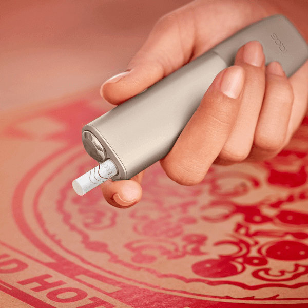 A person places a TEREA stick into an IQOS ILUMA PRIME Holder.