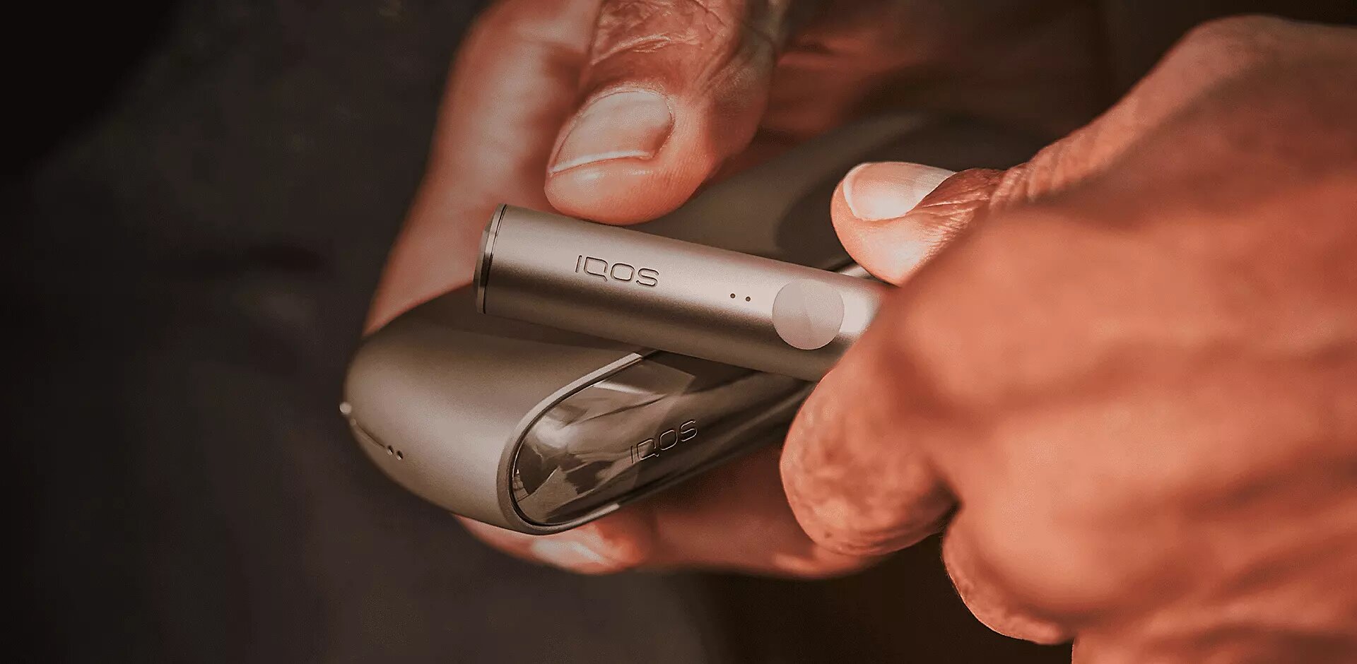 يدان يلامسان قبضتهما وشخص ما يحمل جهاز IQOS ILUMA.