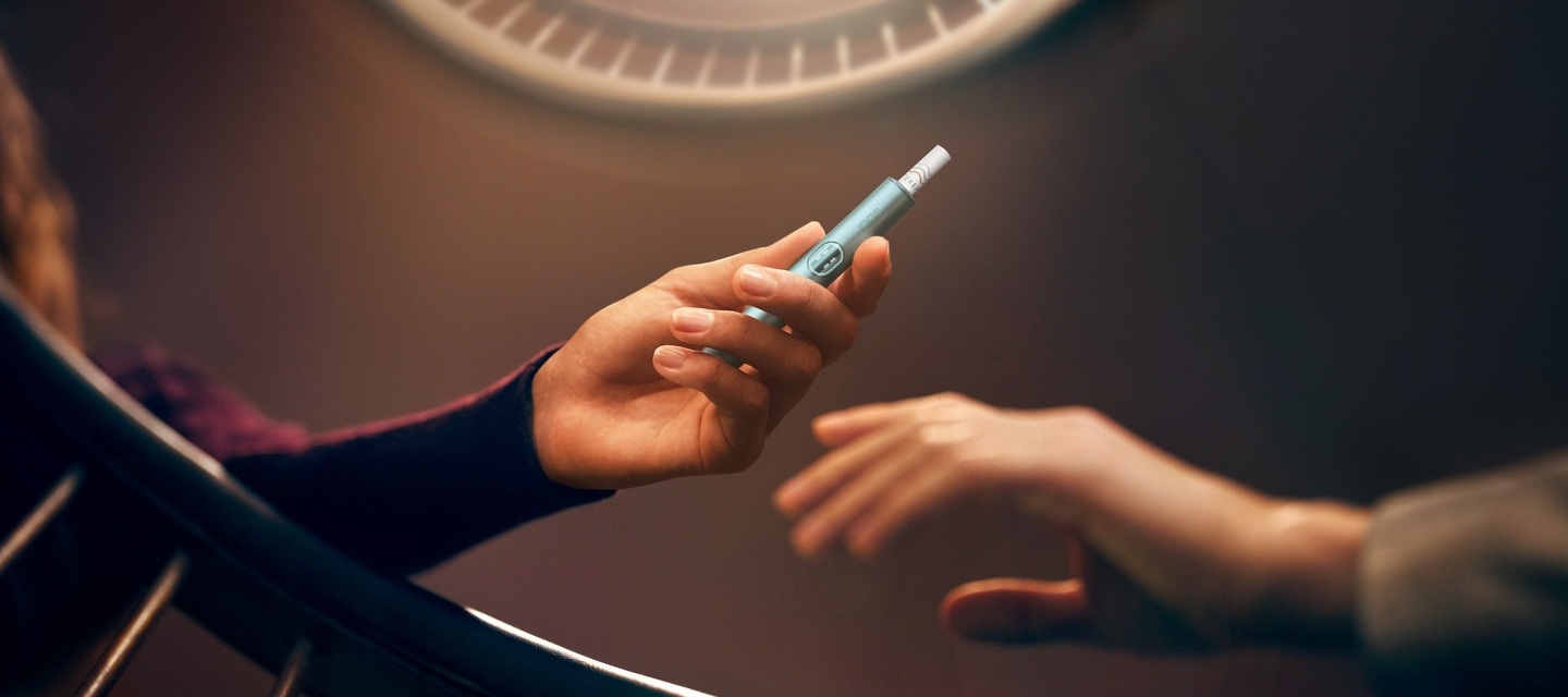 أيدي تقوم بفتح علبة جهاز IQOS ILUMA i