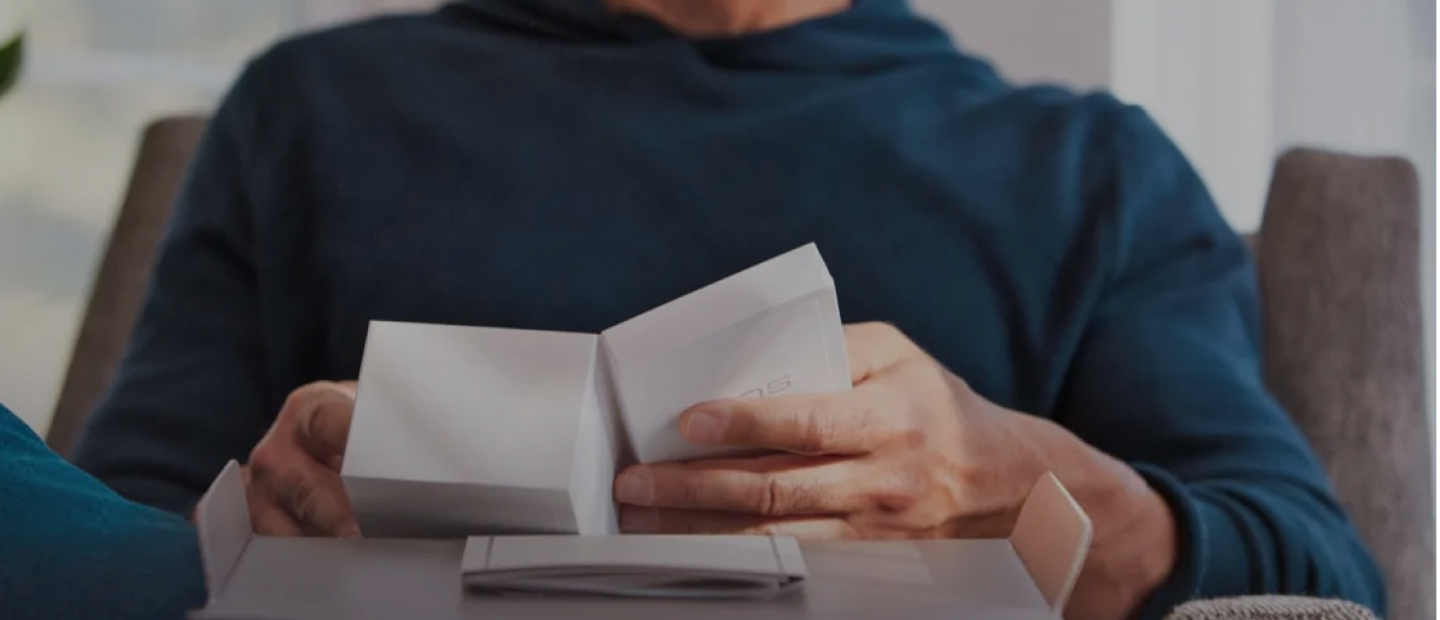 Hands unboxing an IQOS ILUMA i device