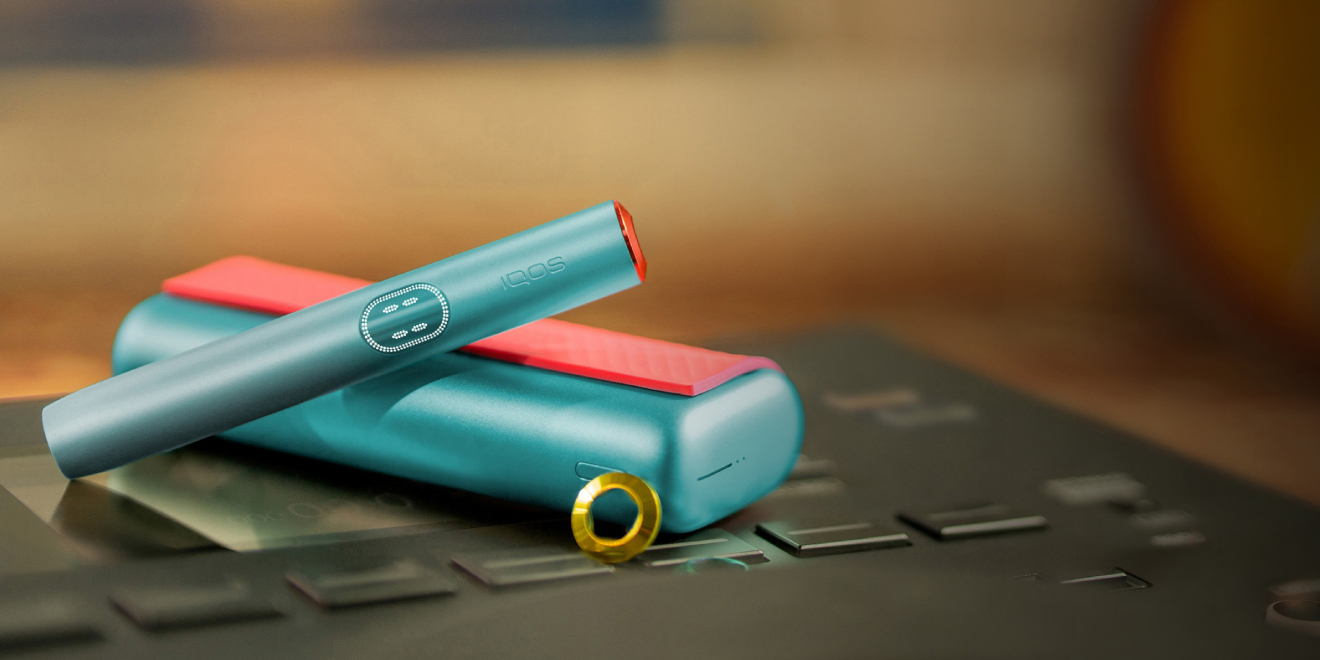 جهاز IQOS ILUMA i PRIME باللون الأزرق فوق شاحنته، مخصص بغطاء وحلقات